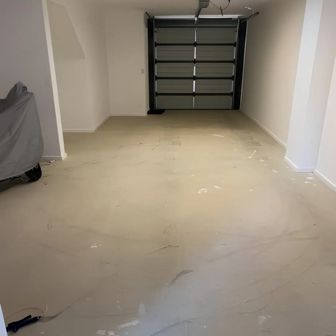Freshly cleared garage with bare concrete floor and a closed roll up door—ready for a makeover