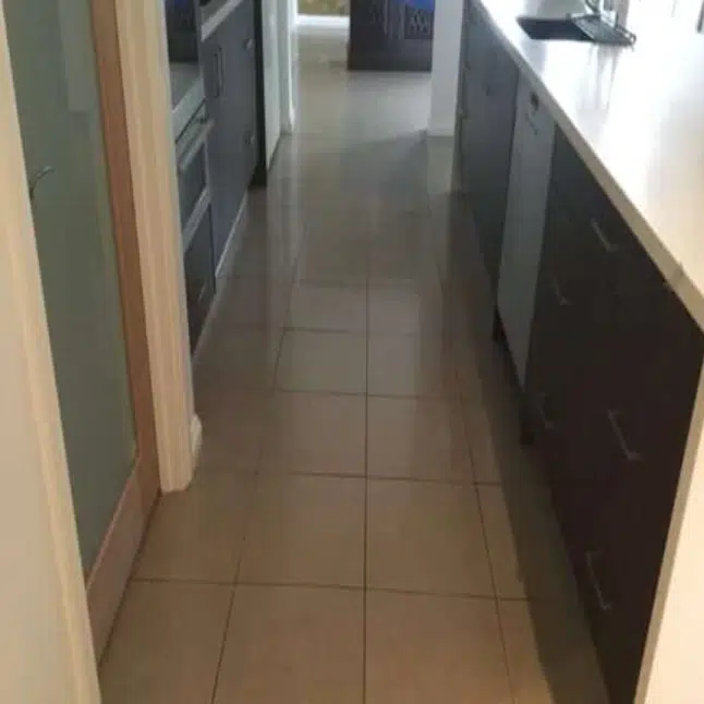 Minimalist living room under renovation with a sunken seating area tiled floors a low wooden coffee table and furniture covered with sheets