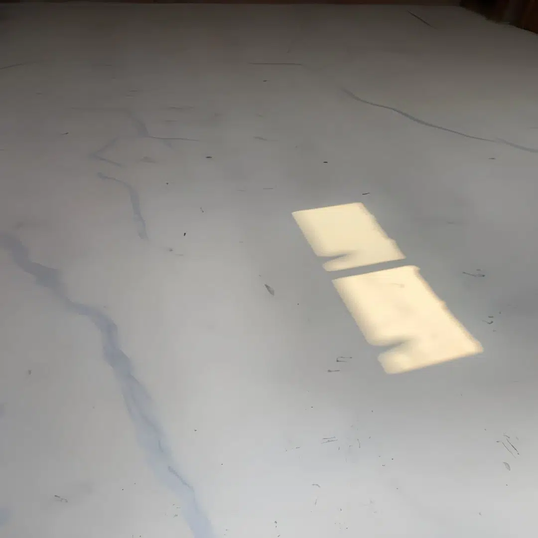 Soft morning light spills onto a smooth concrete floor highlighting faint winding cracks like quiet rivers